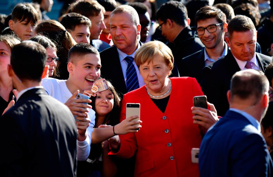 Merkel poses for photos with students as she visits a secondary school in Berlin in April 2019.