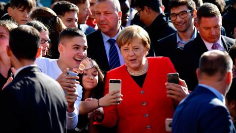 Merkel poses for photos with students as she visits a secondary school in Berlin in April 2019.