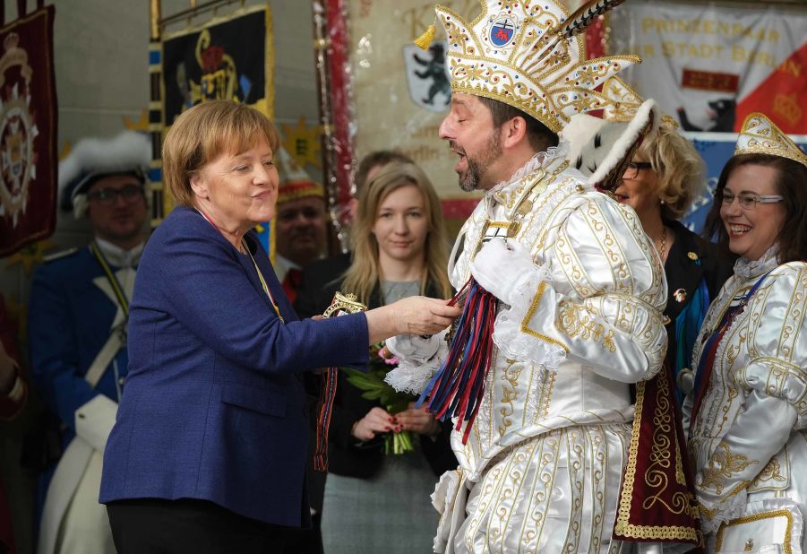 Merkel touches the scepter of a Carnival prince during the annual Carnival reception in Berlin in February 2019.