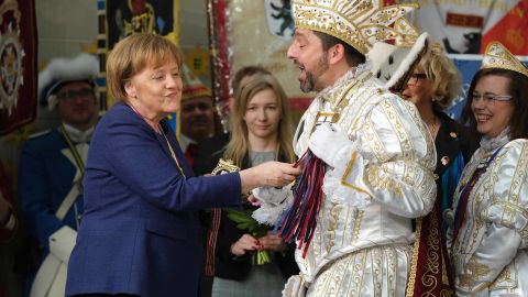 Merkel touches the scepter of a Carnival prince during the annual Carnival reception in Berlin in February 2019.