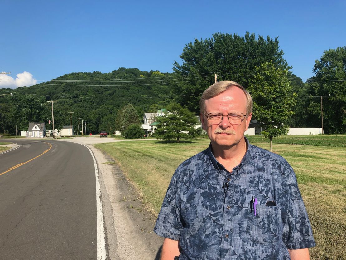 Dennis Knobloch, the mayor of Valmeyer during the 1993 flood, stands in front of the grassy lot where his house once stood on Main Street. Both sides of the road were lined with homes and businesses before the flood.