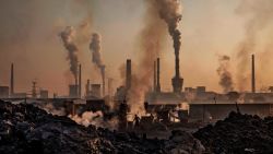 INNER MONGOLIA, CHINA - NOVEMBER 04: Smoke billows from a large steel plant as a Chinese labourer works at an unauthorized steel factory, foreground, on November 4, 2016 in Inner Mongolia, China. To meet China's targets to slash emissions of carbon dioxide, authorities are pushing to shut down privately owned steel, coal, and other high-polluting factories scattered across rural areas. In many cases, factory owners say they pay informal 'fines' to local inspectors and then re-open. The enforcement comes as the future of U.S. support for the 2015 Paris Agreement is in question, leaving China poised as an unlikely leader in the international effort against climate change. U.S. president-elect Donald Trump has sent mixed signals about whether he will withdraw the U.S. from commitments to curb greenhouse gases that, according to scientists, are causing the earth's temperature to rise. Trump once declared that the concept of global warming was "created" by China in order to hurt U.S. manufacturing. China's leadership has stated that any change in U.S. climate policy will not affect its commitment to implement the climate action plan. While the world's biggest polluter, China is also a global leader in establishing renewable energy sources such as wind and solar power. (Photo by Kevin Frayer/Getty Images)