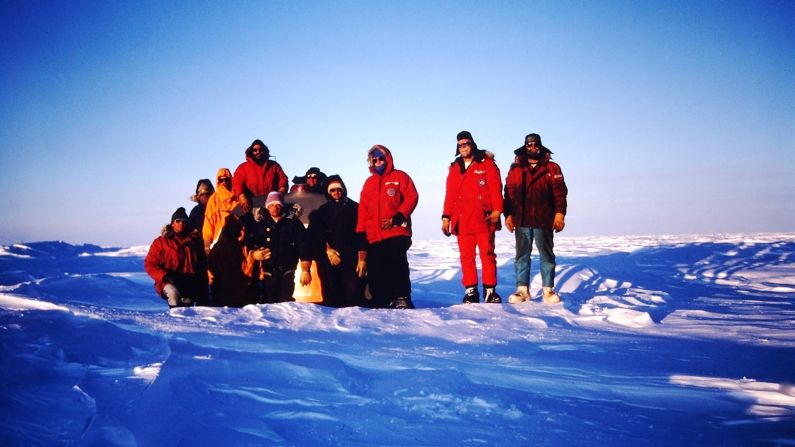 <strong>The team, November 23, 1986:  </strong>This was "taken the night we arrived at D-59 after our traverse from the Adelie Land coast," says Mathews. "The entire group, American and French, are next to 321's tail.  You can see how deeply it was buried." Left to right: J. Mathews, R. Biery, P. Delay, G. Cameron, E. Puvillard, P. Laffont, D. Simon, M. Brashears, D. Check, R. Magsig. 