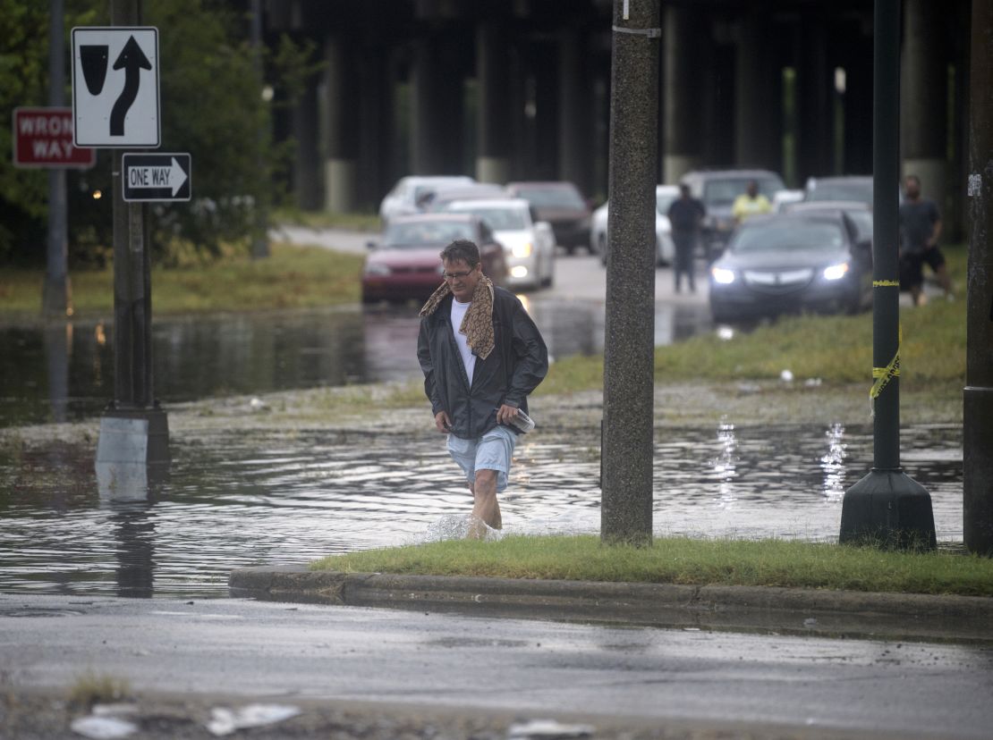 A man walks through standing water in New Orleans after a severe thunderstorm caused flooding. 