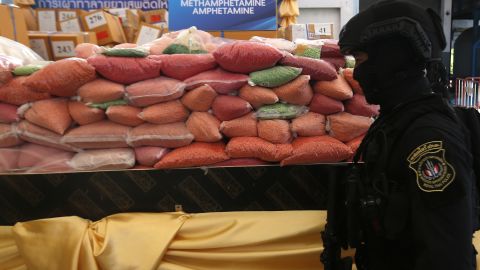A police officer from Thailand's Narcotics Control Board stands guard in front of bags of methamphetamine pills in Ayutthaya province, north of Bangkok.