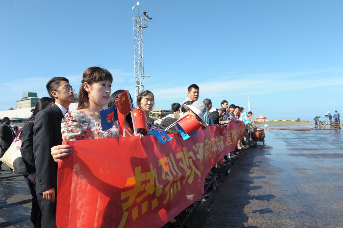 Chinese Fijians display banners on the arrival of the Peace Ark, the hospital ship of China's People's Liberation Army Navy, at Suva Port in Suva, Fiji, on August 22, 2014. 