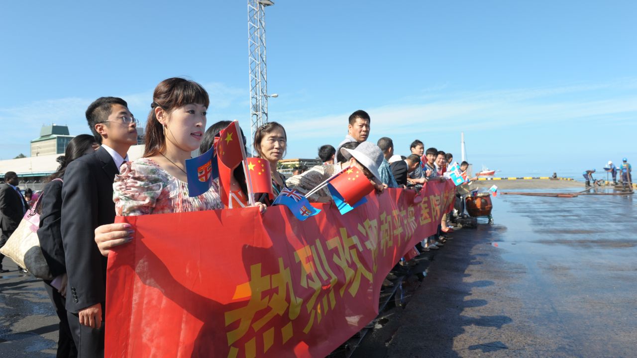 Chinese Fijians display banners on the arrival of the Peace Ark, the hospital ship of China's People's Liberation Army Navy, at Suva Port in Suva, Fiji, on August 22, 2014. 