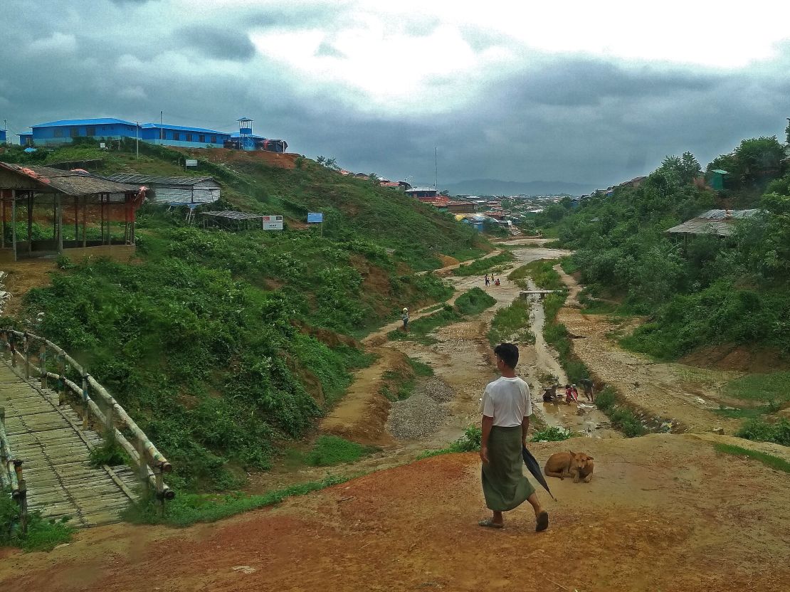 A Rohingya man walks through the refugee camp to his home before another round of rain. 