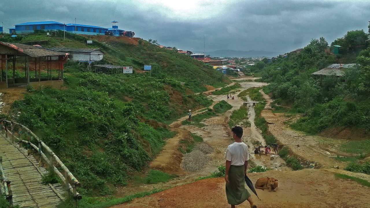 A Rohingya man walks through the refugee camp to his home before another round of rain. 