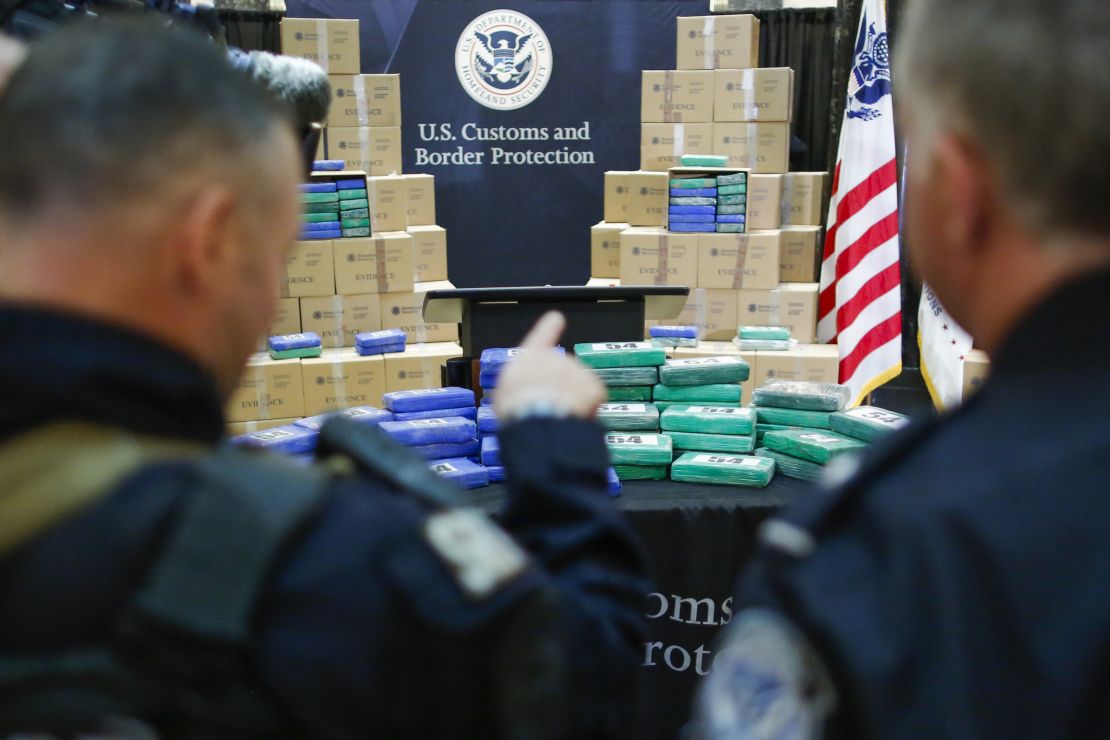 Police officers stand guard near cocaine seized from the cargo ship.