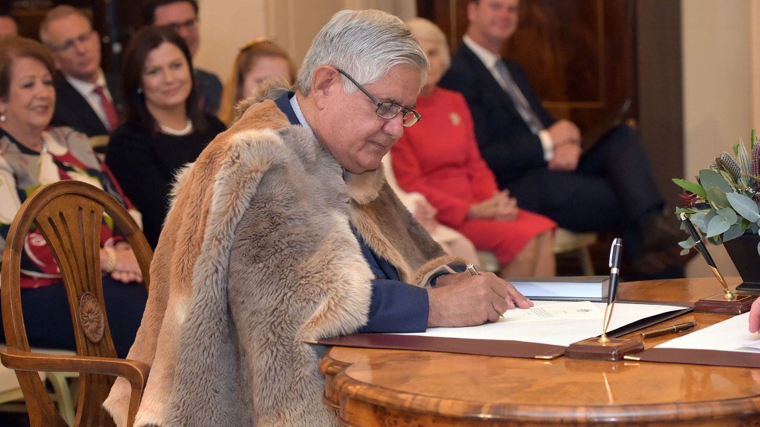Minister for Indigenous Australians Ken Wyatt signs a document during an oath-taking ceremony at Government House in Canberra on May 29, 2019.