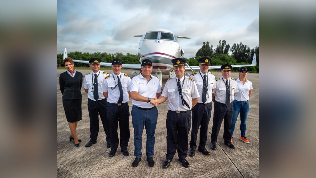 The crew pose in front of the craft.