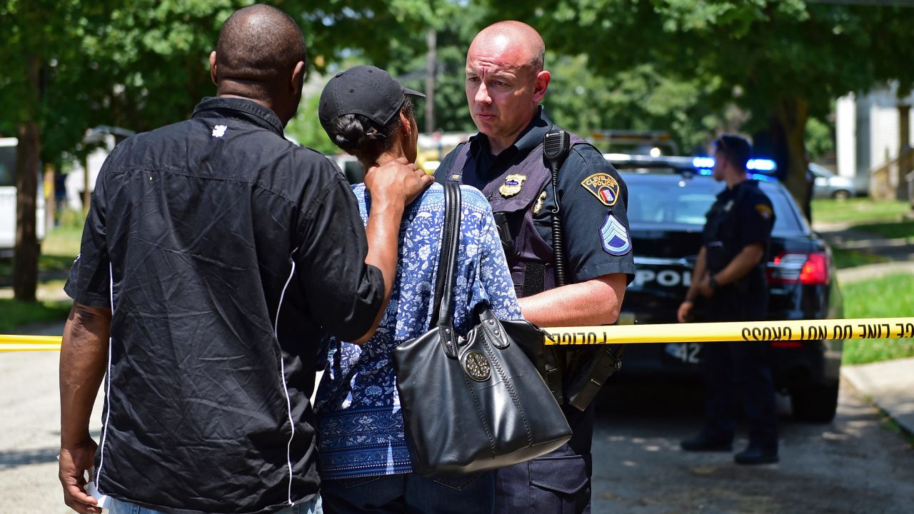 Police investigators in Cleveland talk with two bystanders.