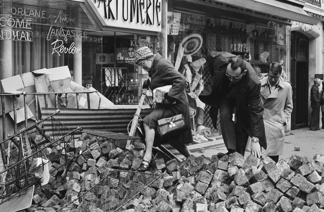 Inhabitants climb over piles of paving stones in the streets during the French student demonstrations in May 1968.