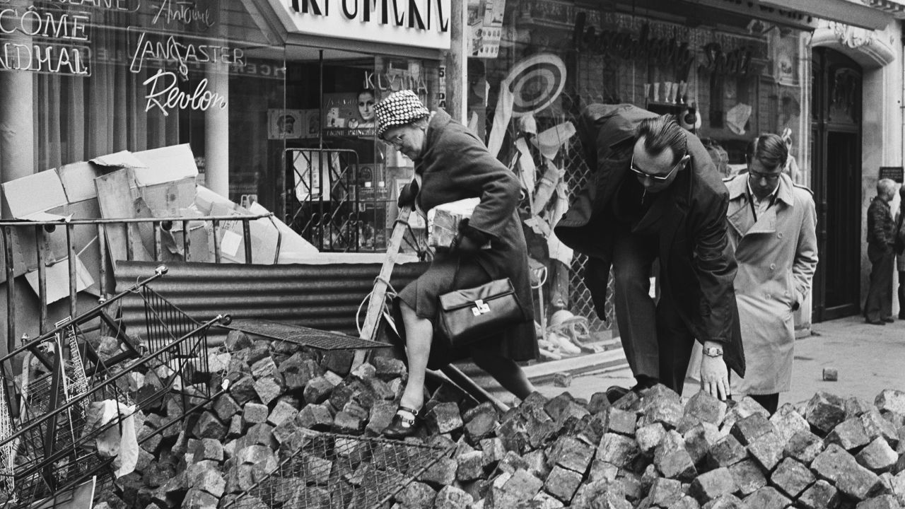 Inhabitants climb over piles of paving stones in the streets during the French student demonstrations in May 1968.
