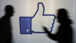 People are seen as silhouettes as they move past an illuminated wall bearing Facebook Inc.s 'Thumbs Up' symbol in this arranged photograph in London, U.K., on Wednesday, Dec. 23, 2015. Facebook Inc.s WhatsApp messaging service, with more than 100 million local users, is the most-used app in Brazil, according to an Ibope poll published on Dec. 15. Photographer: Chris Ratcliffe/Bloomberg via Getty Images
