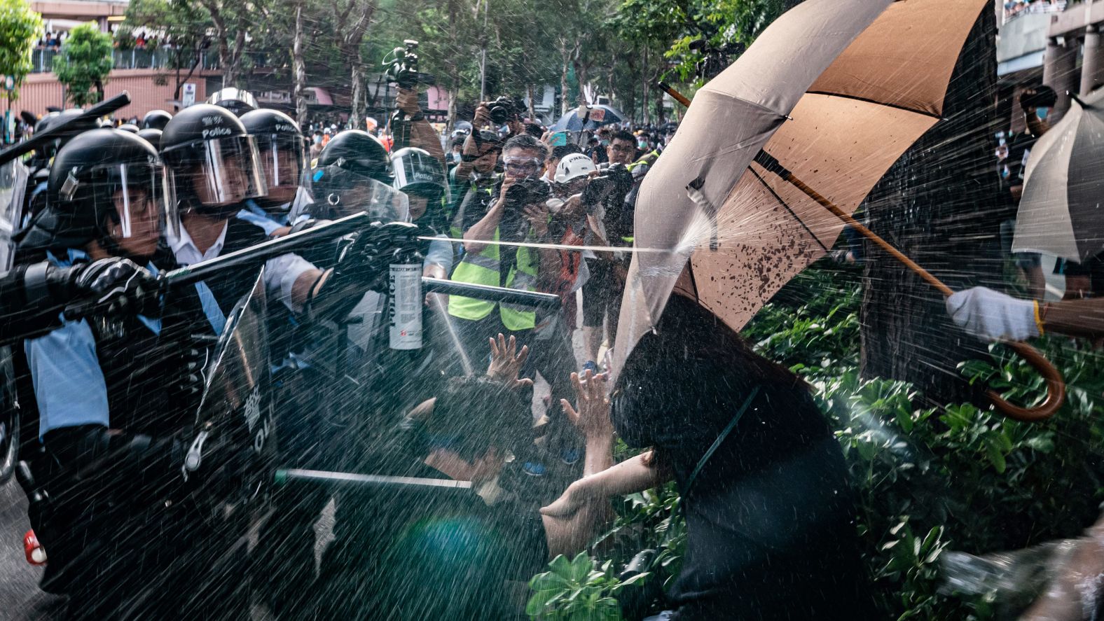 Police officers use pepper spray to disperse protesters after a rally in the Sheung Shui district on Saturday, July 13.