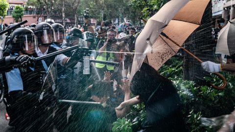 Police officers use pepper spray to disperse protesters after a rally in the Sheung Shui district on Saturday, July 13. 