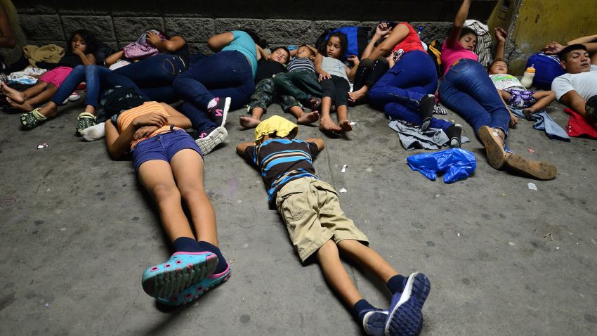 TOPSHOT - Honduran families sleep in the streets waiting to board a bus leaving the Metropolitan Center of San Pedro Sula, 300 kms north of Tegucigalpa, to travel to the Guatemala border on April 9, 2019. - At least one thousand of Hondurans migrants including women and children were convened by social medias to a new caravan to the US. About four caravans of 2,000 hondurans left San Pedro Sula between October 2018 and January 2019 escaping violence and poverty. (Photo by ORLANDO SIERRA / AFP)        (Photo credit should read ORLANDO SIERRA/AFP/Getty Images)