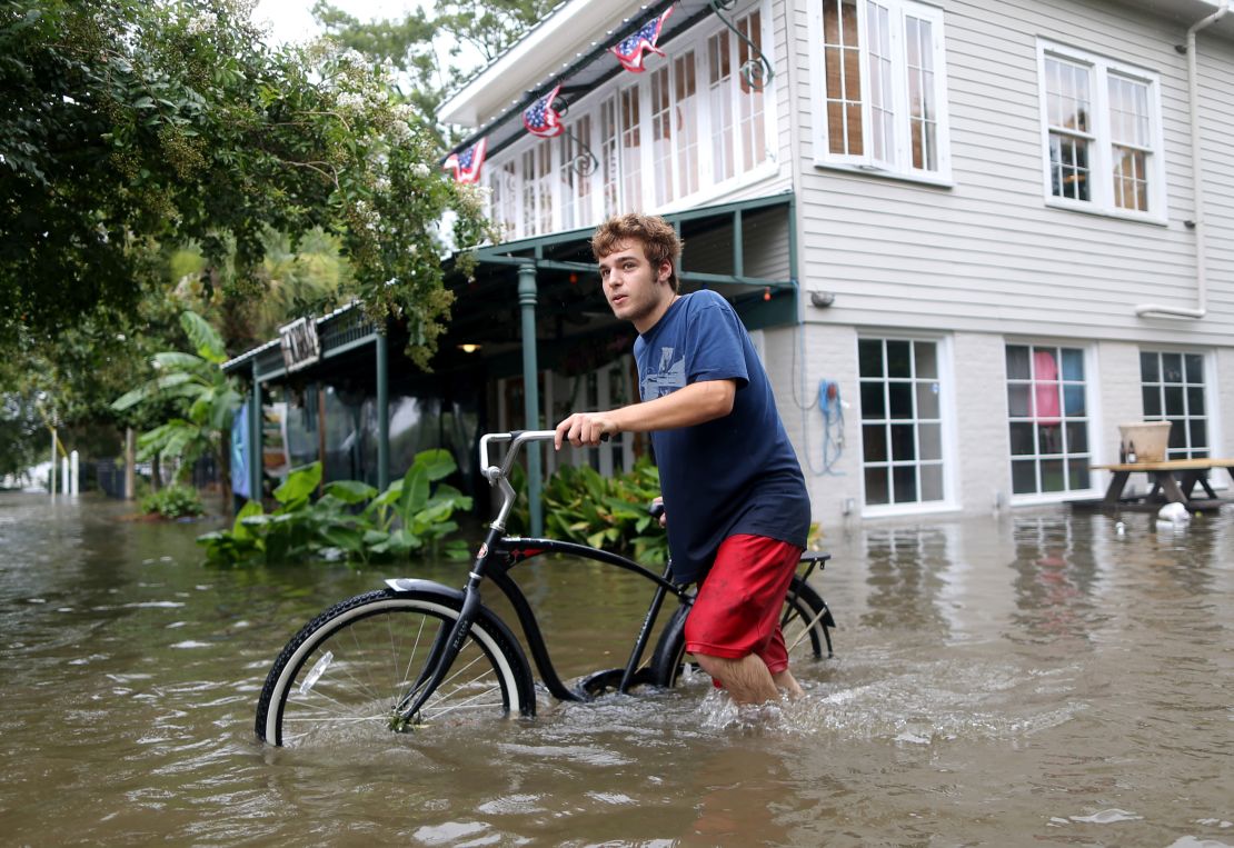 Logan Courvlle pushes his bike through a flooded street after Hurricane Barry in Mandeville, Louisiana, on July 13.