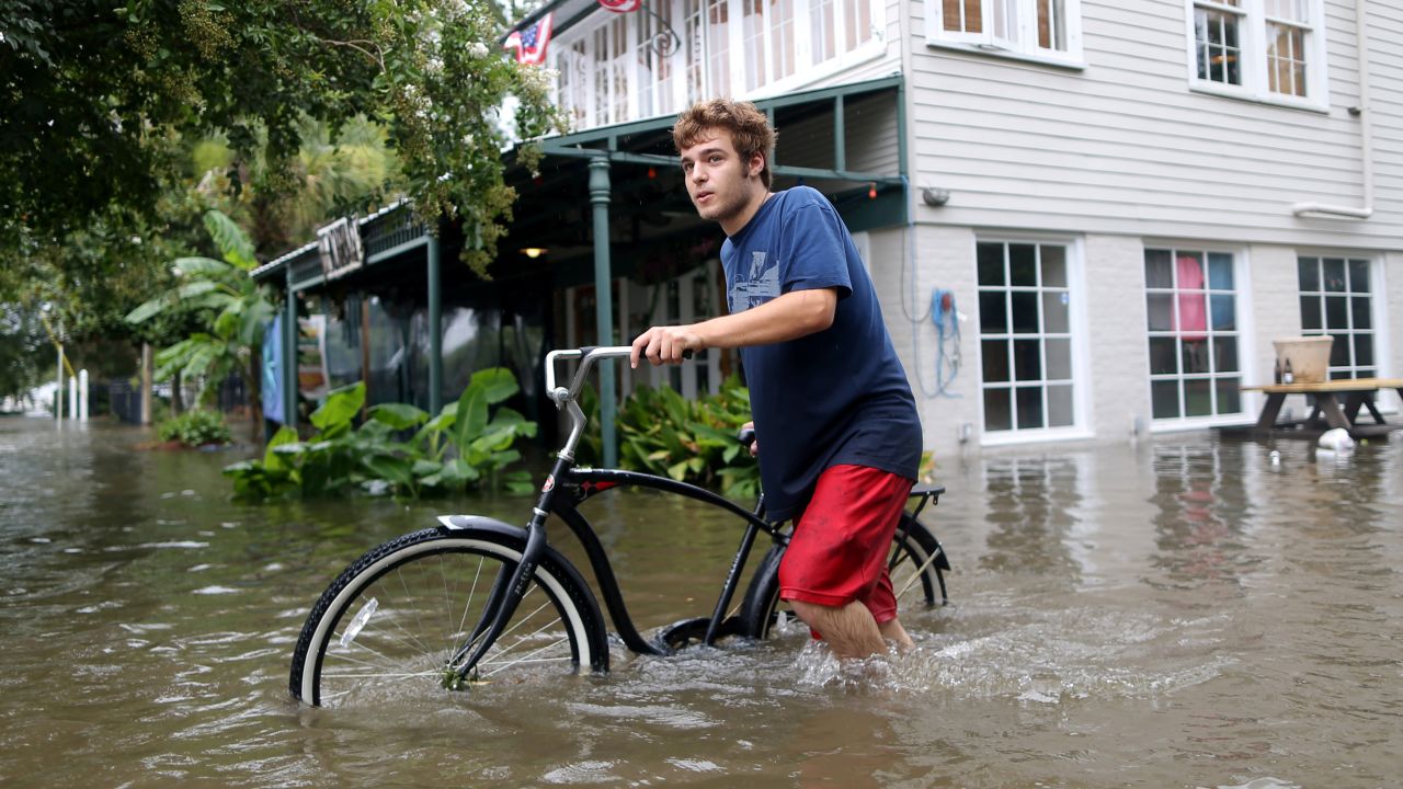Logan Courvlle pushes his bike through a flooded street after Hurricane Barry in Mandeville, Louisiana, on July 13.