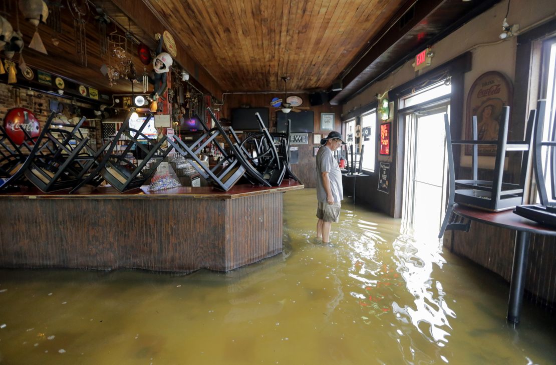 A man stands in floodwaters Saturday at Don'z On the Lake in Mandeville, Louisiana.