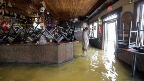 A man stands in floodwaters at Don'z On the Lake as Tropical Storm Barry's winds push water over the Lake Pontchartrain seawall on July 13.