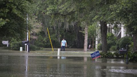 A man stands in flood water outside a home near Lake Pontchartrain.