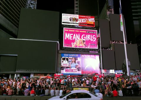 Times Square's billboards are black as people fill the street.