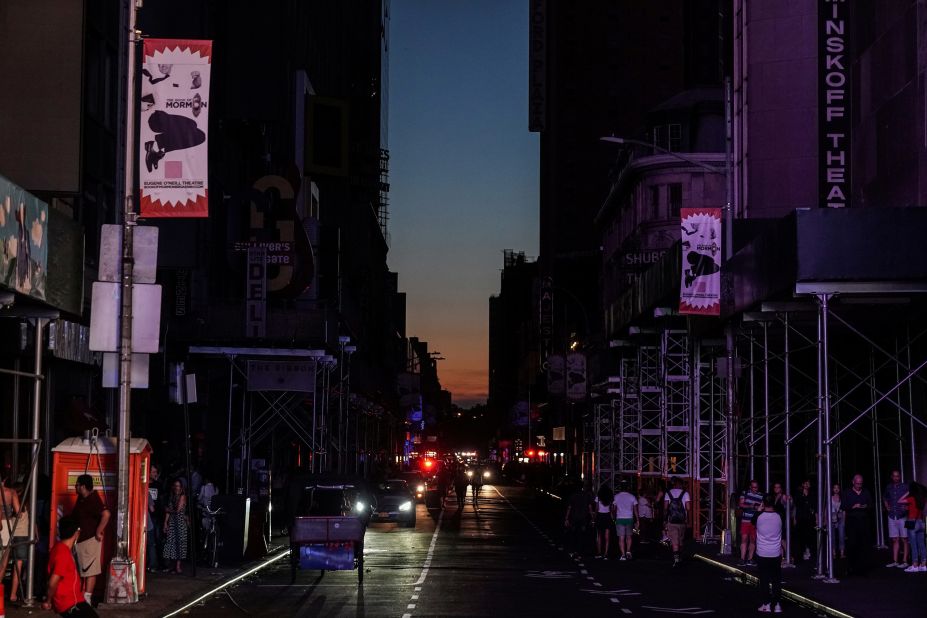 Dark buildings along a dark street are seen near the Times Square area.