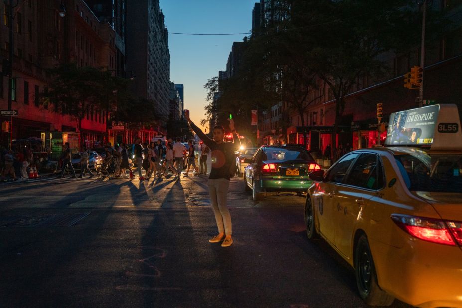 A man directs traffic on 8th Avenue and West 58th Street.