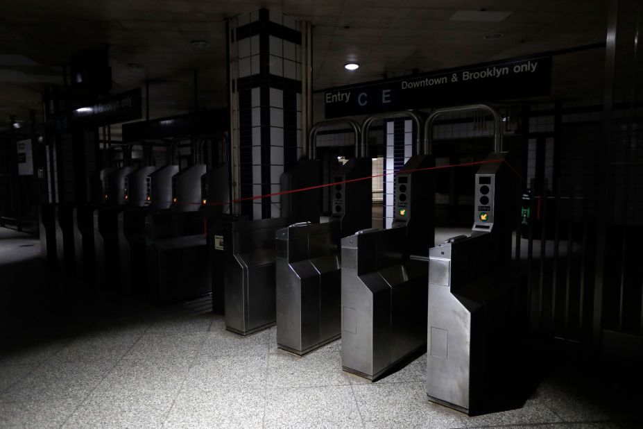 An entrance to the C and E trains at the 50th Street Subway Station is dimly lit.