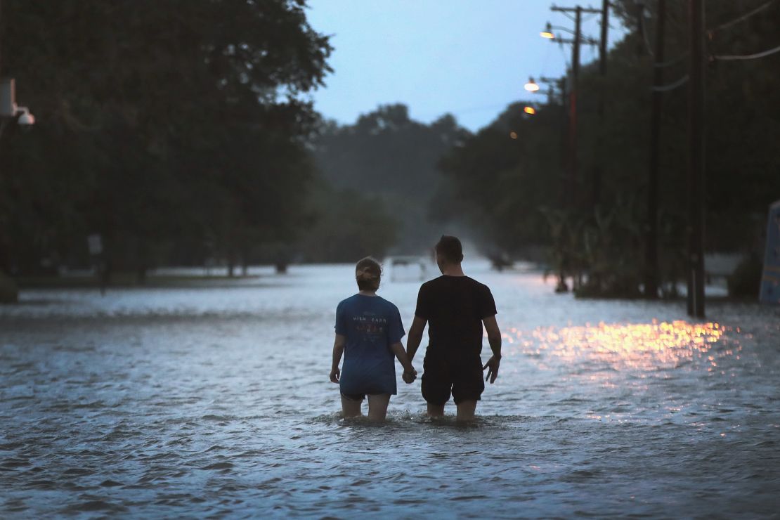 A couple walks through floodwater on Lakeshore Drive near Lake Pontchartrain.