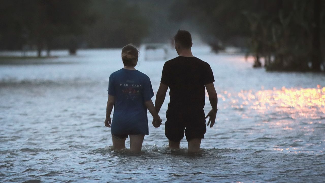 A couple walks through floodwater on Lakeshore Drive near Lake Pontchartrain.