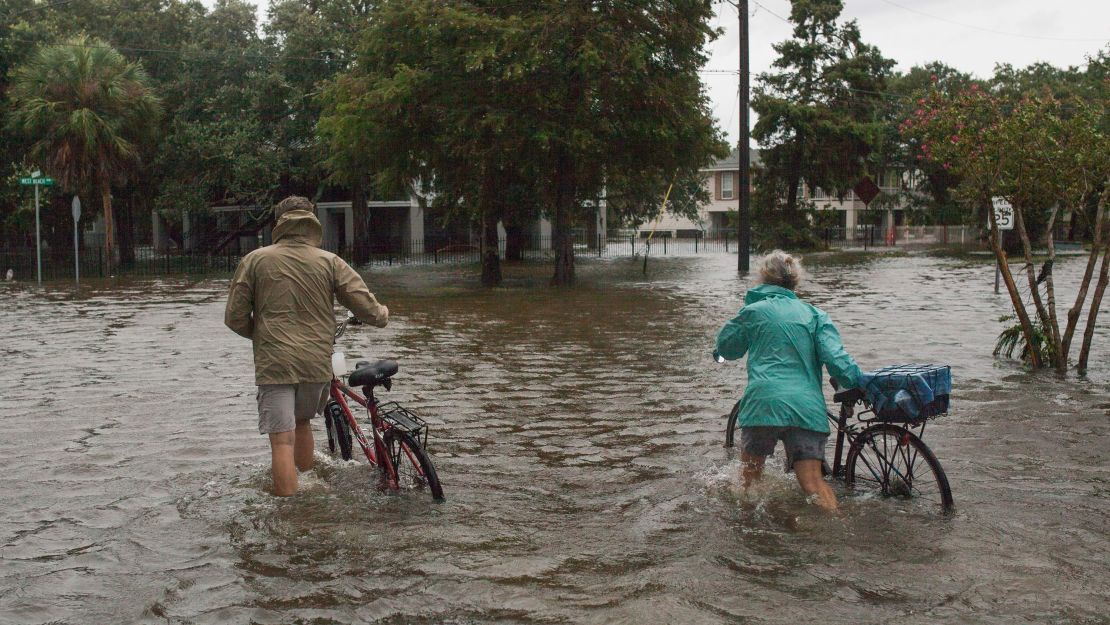 A couple walks through a flooded street Sunday in Mandeville, Louisiana.