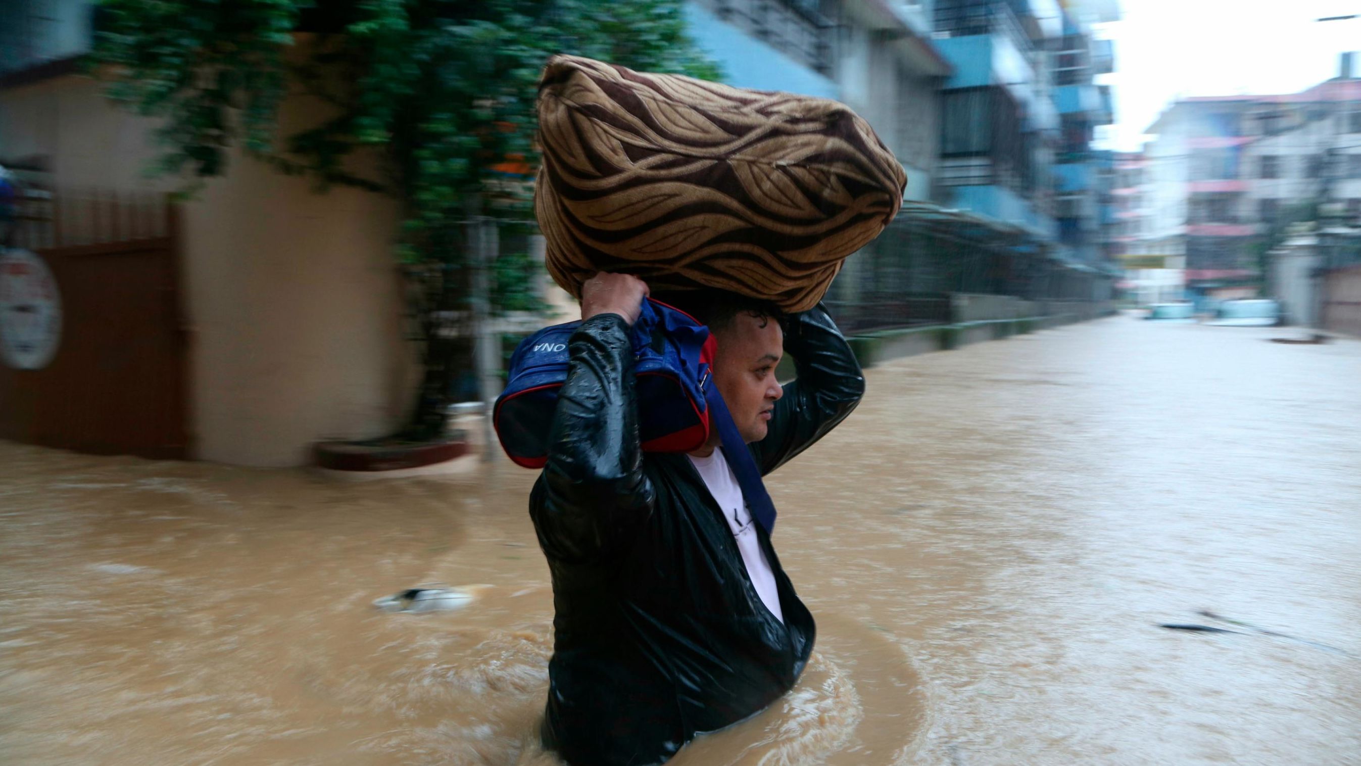 A Nepalese man wades through a flooded street in Kathmandu, Nepal, on July 12, 2019.