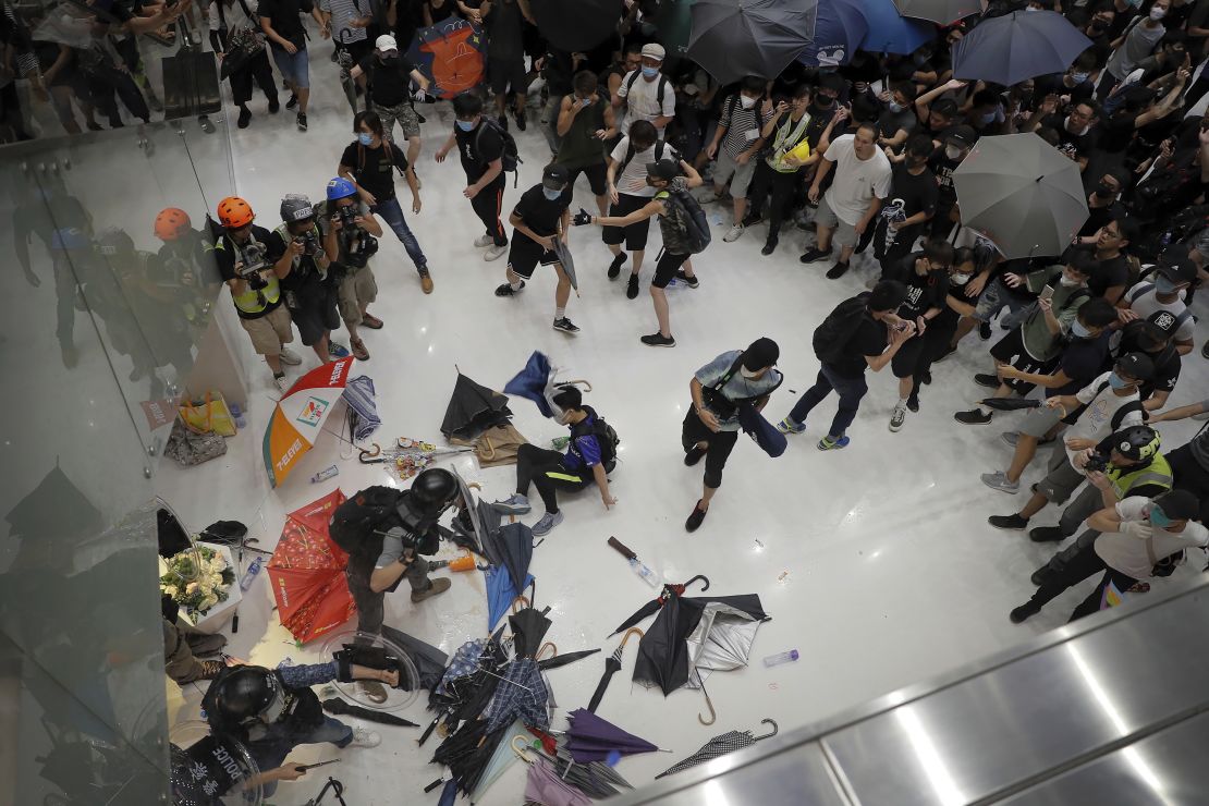 Policemen scuffle with protesters inside a shopping mall in Sha Tin District in Hong Kong on July 14, 2019. 