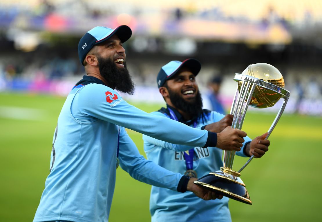 Moeen Ali of England and Adil Rashid of England parade the World Cup trophy.