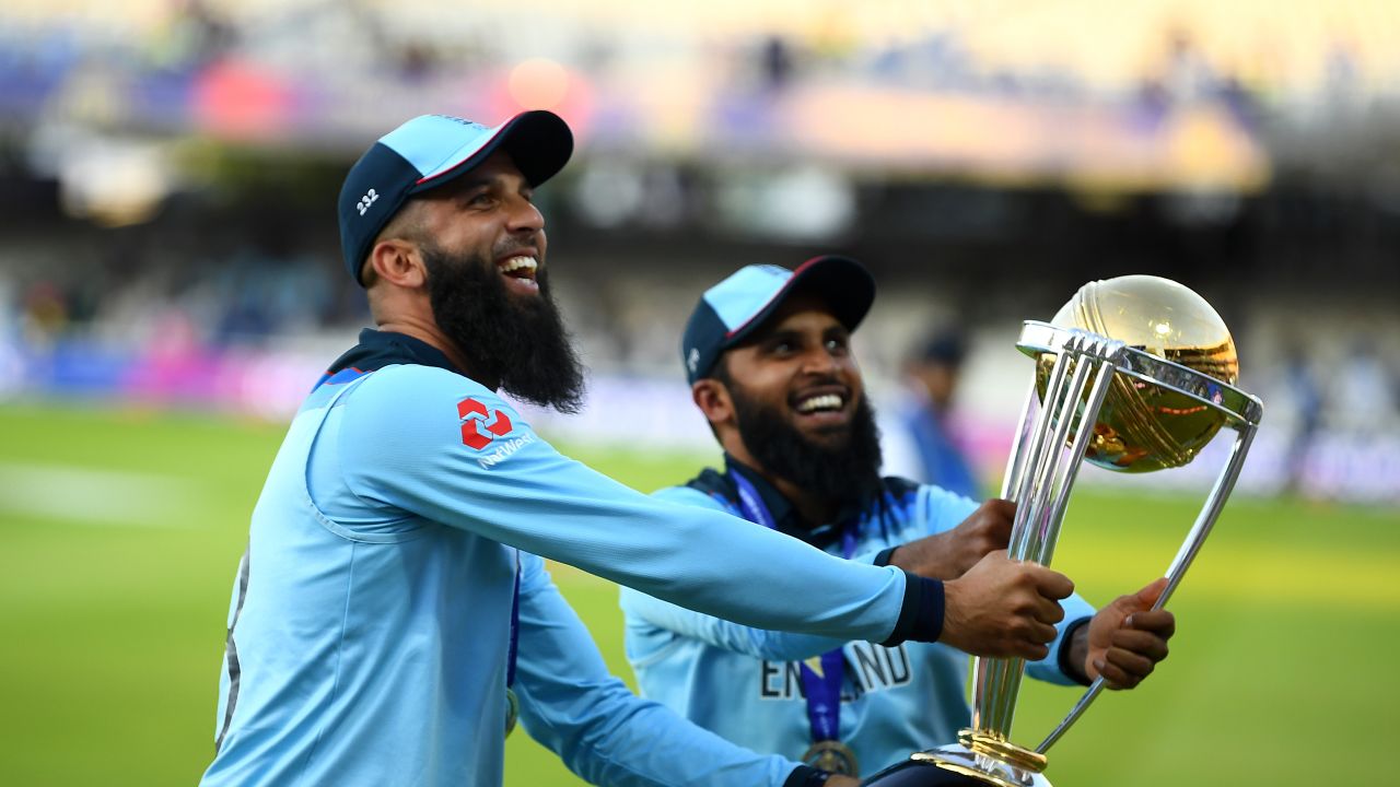 Moeen Ali of England and Adil Rashid of England parade the World Cup trophy.