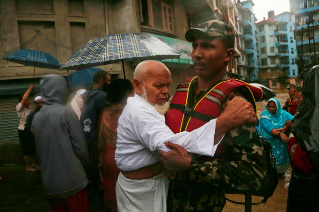 A Nepalese soldier moves an elderly man to a safer area in Kathmandu on July 12, 2019. 