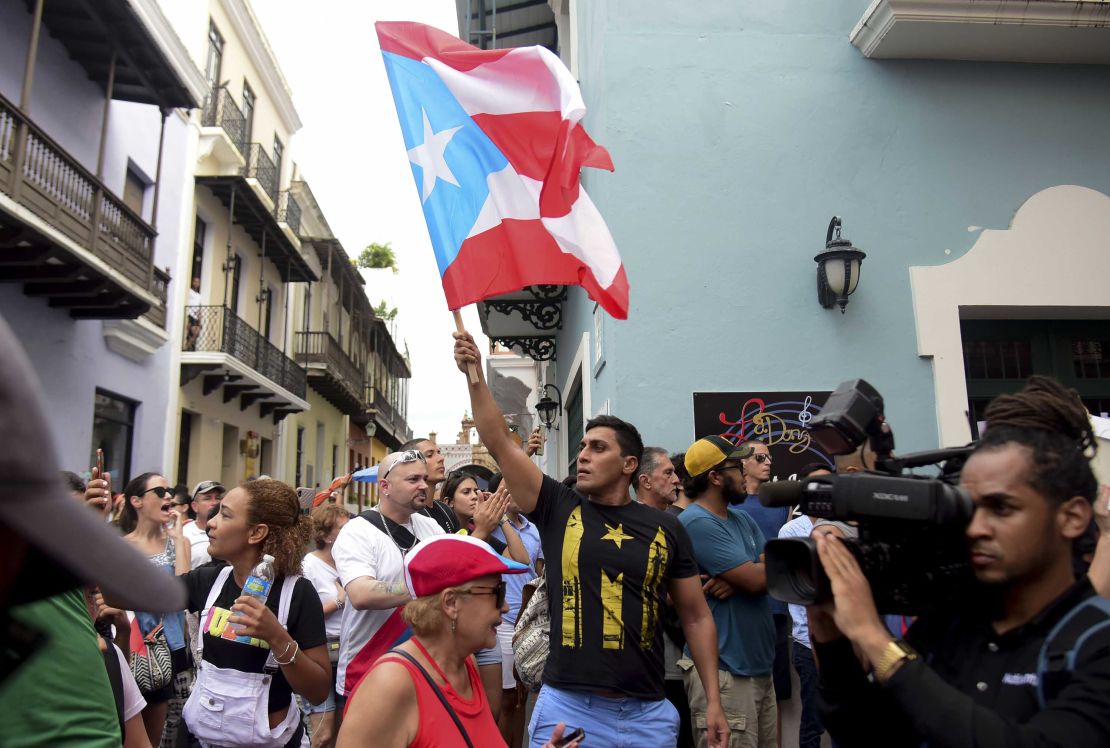 A man waves a Puerto Rican flag during a protest Sunday near La Fortaleza governor's residence in San Juan.
