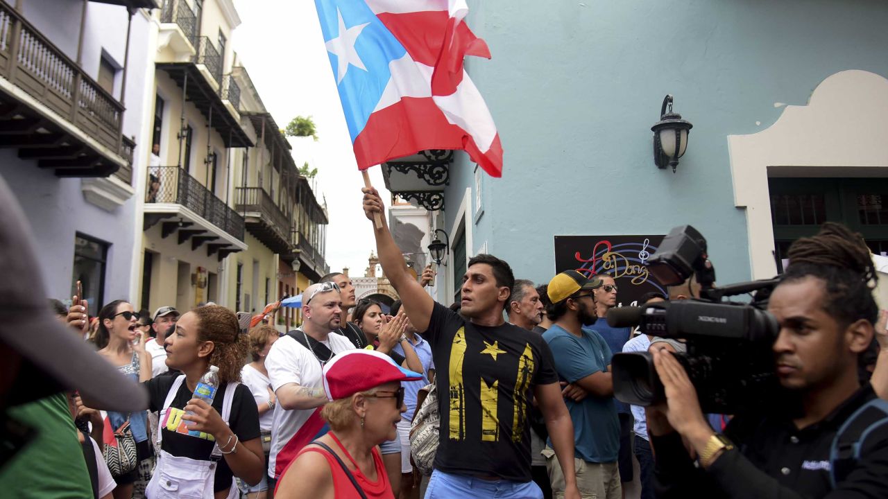 A man waves a Puerto Rican flag during a protest Sunday near La Fortaleza governor's residence in San Juan.
