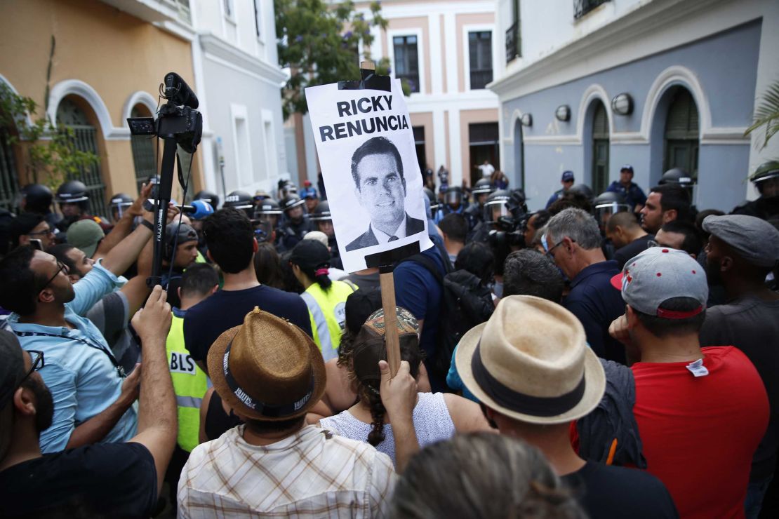 "Ricky resign," reads a sign at a protest demanding Rosselló's resignation. 