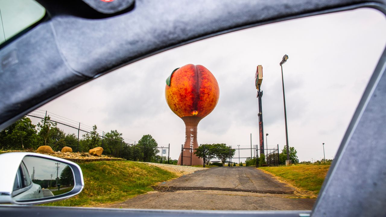 Peachoid, a 135 foot-tall water tower in Gaffney, South Carolina, painted to look like a peach, is seen through the Tesla's window.