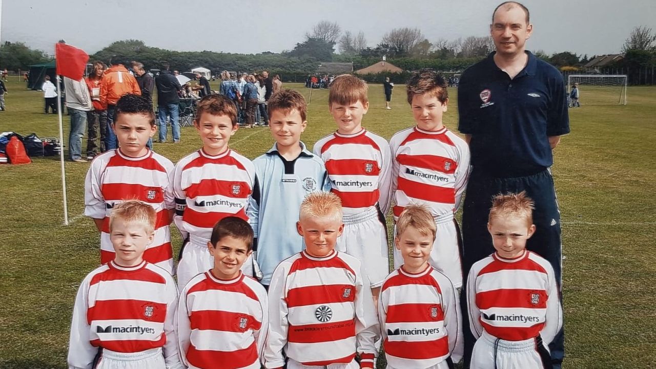 Christian Pulisic (bottom row, second from left) with his Brackley Town team and coach Robin Walker. 