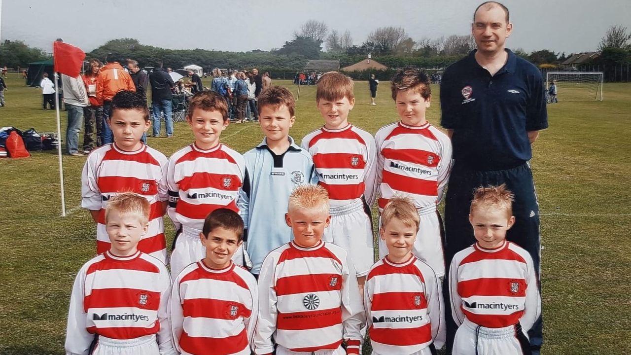 Christian Pulisic (bottom row, second from left) with his Brackley Town team and coach Robin Walker.