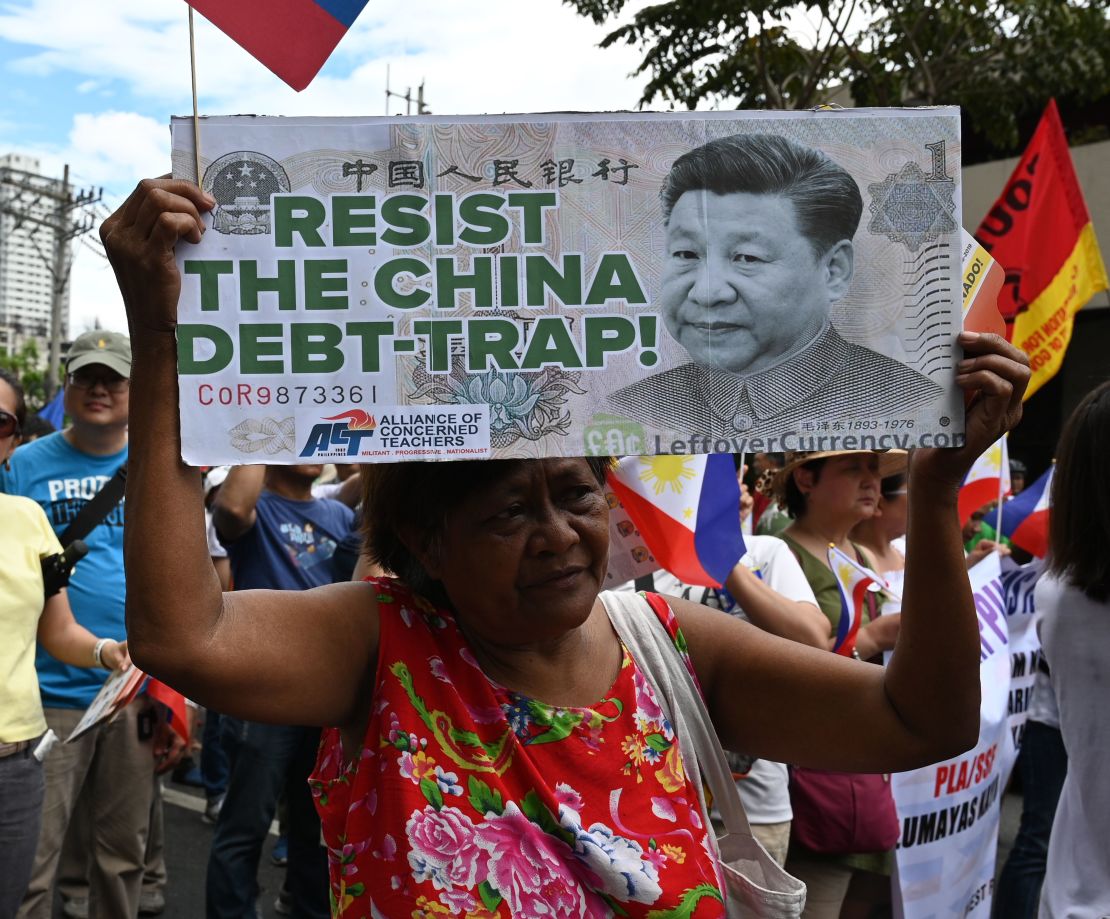 An anti-China protester raises a placard with a portrait of Chinese President Xi Jinping during a protest in front of the Chinese consular office in the financial district of Manila on April 9.