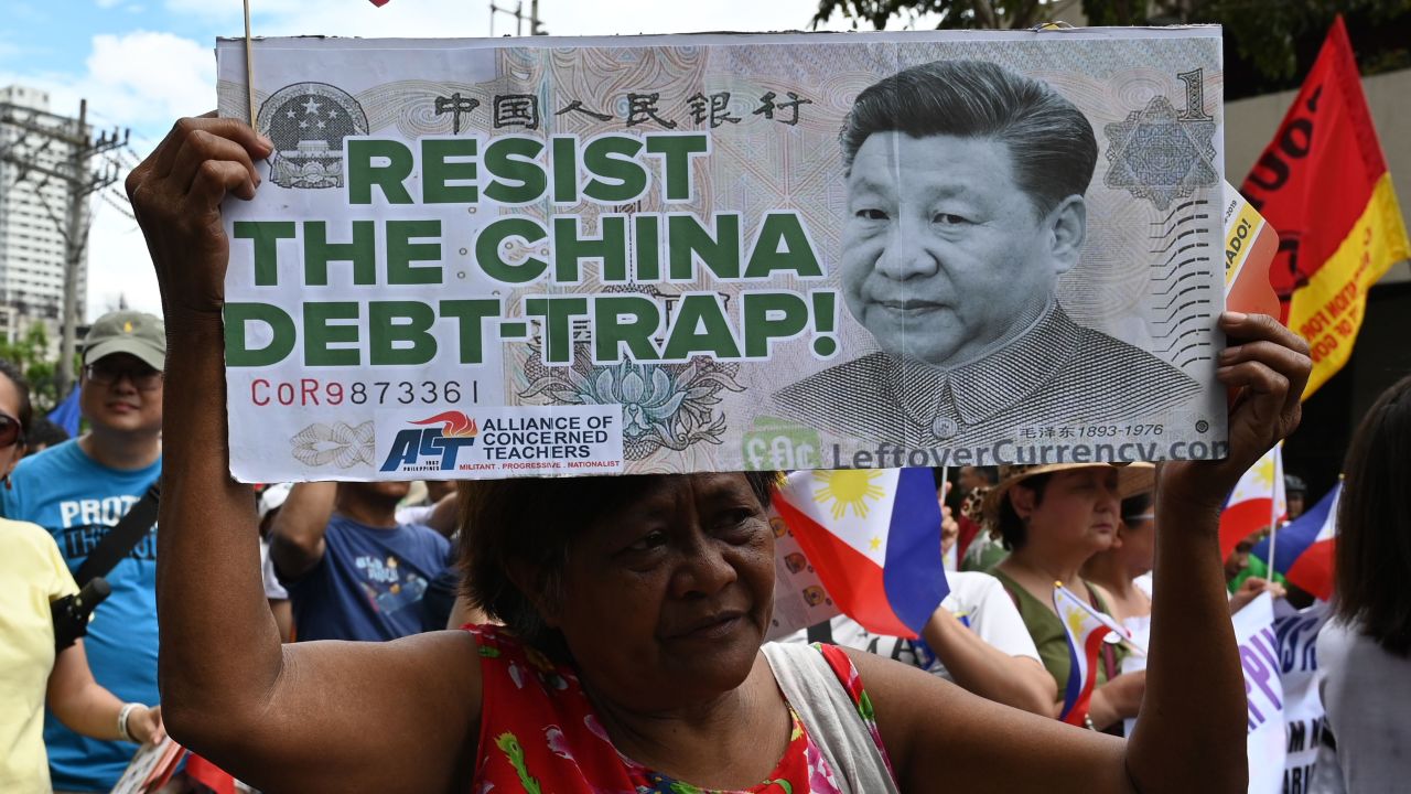 An anti-China protester raises a placard with a portrait of Chinese President Xi Jinping during a protest in front of the Chinese consular office in the financial district of Manila on April 9.