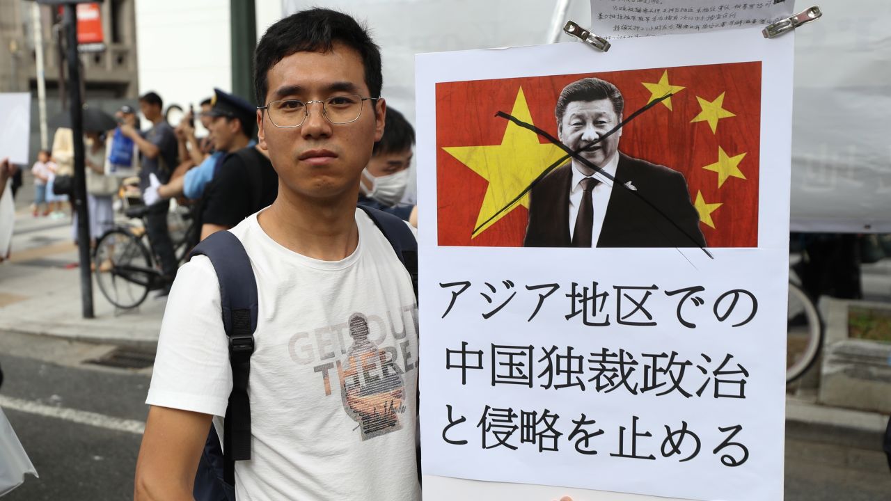 People chant slogans and wave flags during a protest march on June 29 in Osaka, Japan.
