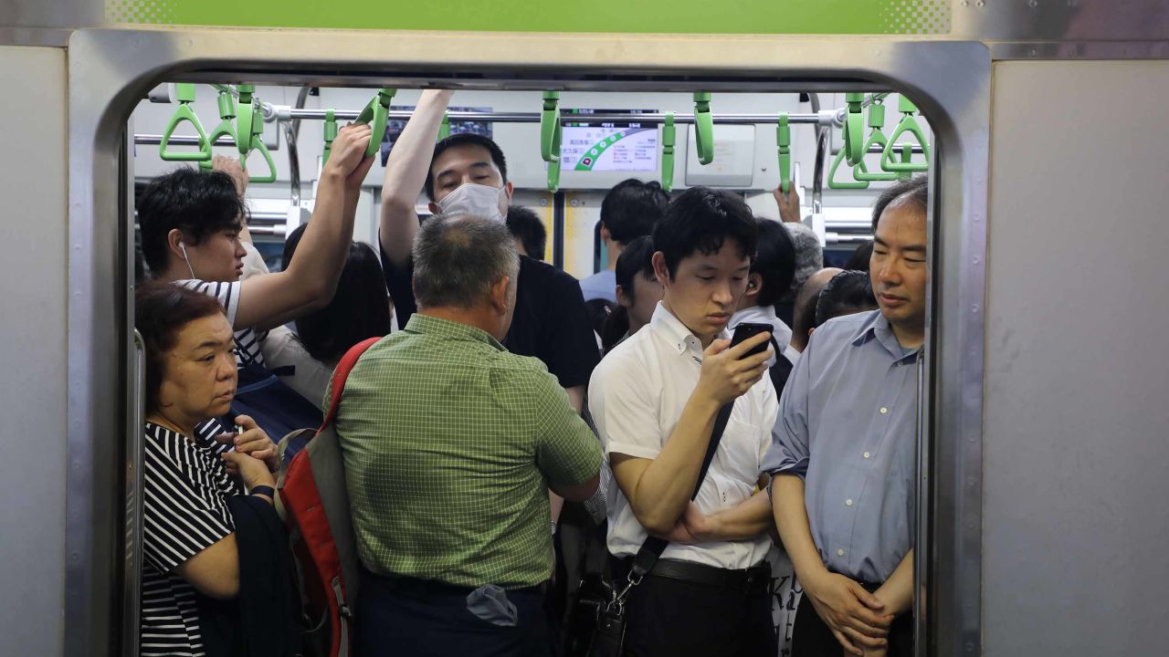 Commuters stand on a crowed metro carriage at rush hour in Tokyo on June 25, 2019.